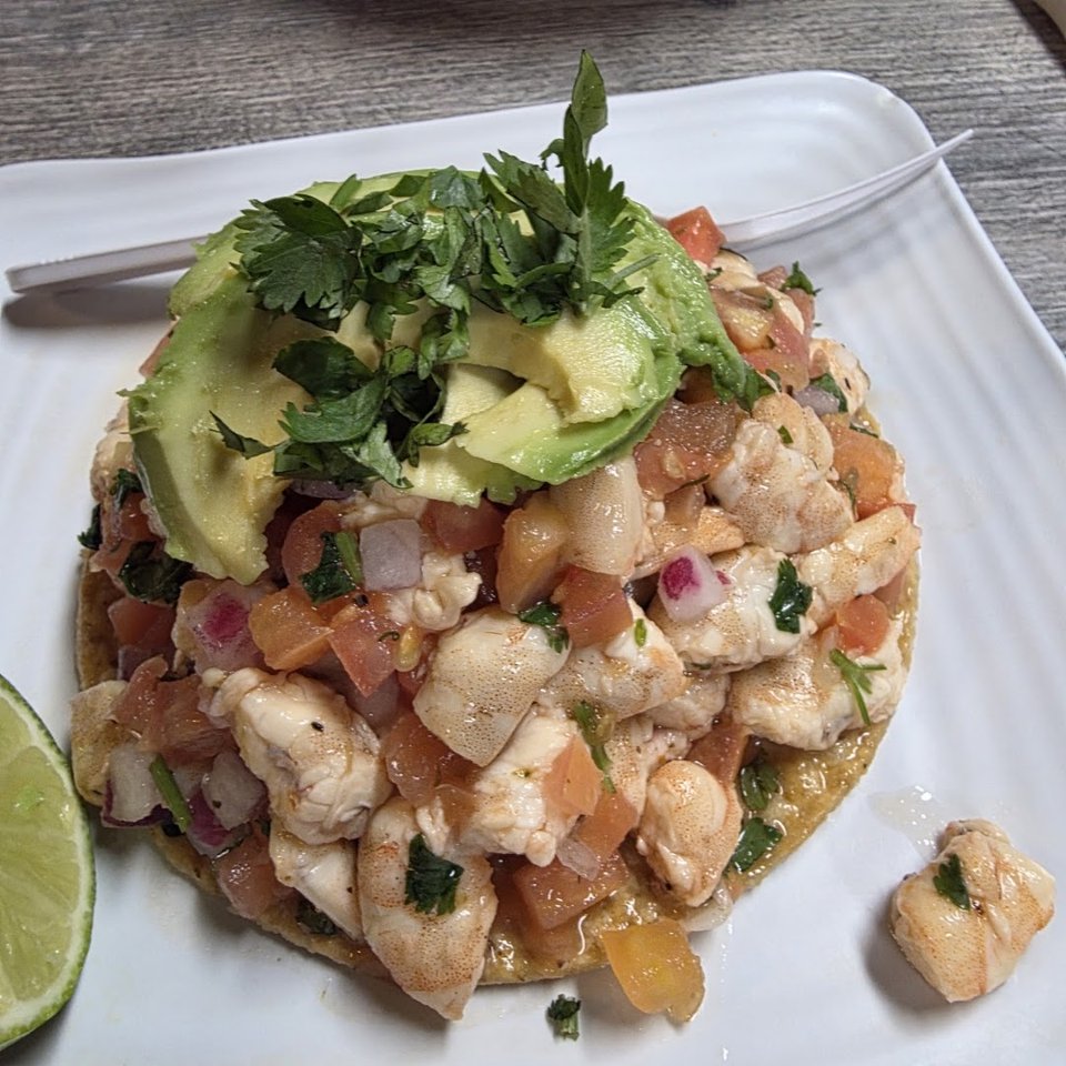 Colorful mariscos dishes served in shallow bowls.